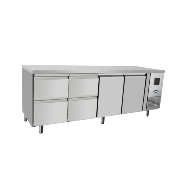 Atosa - Tavolo frigo 700 TN 2 porta GN 1/1 + 2 cassettiera 1/2 Il tavolo refrigerato ha una struttura interna ed esterna interamente realizzata in acciaio INOX, compreso il pannello posteriore. Il tavolo è regolabile in altezza grazie alla presenza di piedini in acciaio INOX. All'interno il tavolo presenta angoli arrotondati per facilitare le operazioni di pulizia e garantire pertanto igiene e praticità. La refrigerazione è ventilata e ciò significa che il freddo viene prodotto da un evaporatore esterno ad alette trattato anticorrosione. Il tavolo ha anche un ricircolo di aria fredda. Il vano di produzione del freddo è infatti situato a destra e quindi, per distribuire il freddo equamente in tutta la larghezza del tavolo, è necessario che il freddo venga incanalato in un controsoffitto che ha delle apposite feritoie che permettono di distribuire uniformemente l'aria refrigerata in tutta la zona di stoccaggio. La temperatura è positiva e si attesta in un range tra -2°C e +8°C. La temperatura può essere costantemente regolata e controllata grazie a un termostato digitale che inoltre regola anche lo sbrinamento del tavolo. L'eliminazione della condensa avviene tramite una resistenza elettrica inserita nella cornice della porta e l'evaporazione dell'acqua è automatica.