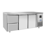 Atosa - Tavolo frigo 700 TN 2 porta GN 1/1 + cassettiera 1/2 Il tavolo refrigerato ha una struttura interna ed esterna interamente realizzata in acciaio INOX, compreso il pannello posteriore. Il tavolo è regolabile in altezza grazie alla presenza di piedini in acciaio INOX. All'interno il tavolo presenta angoli arrotondati per facilitare le operazioni di pulizia e garantire pertanto igiene e praticità. La refrigerazione è ventilata e ciò significa che il freddo viene prodotto da un evaporatore esterno ad alette trattato anticorrosione. Il tavolo ha anche un ricircolo di aria fredda. Il vano di produzione del freddo è infatti situato a destra e quindi, per distribuire il freddo equamente in tutta la larghezza del tavolo, è necessario che il freddo venga incanalato in un controsoffitto che ha delle apposite feritoie che permettono di distribuire uniformemente l'aria refrigerata in tutta la zona di stoccaggio. La temperatura è positiva e si attesta in un range tra -2°C e +8°C. La temperatura può essere costantemente regolata e controllata grazie a un termostato digitale che inoltre regola anche lo sbrinamento del tavolo. L'eliminazione della condensa avviene tramite una resistenza elettrica inserita nella cornice della porta e l'evaporazione dell'acqua è automatica.